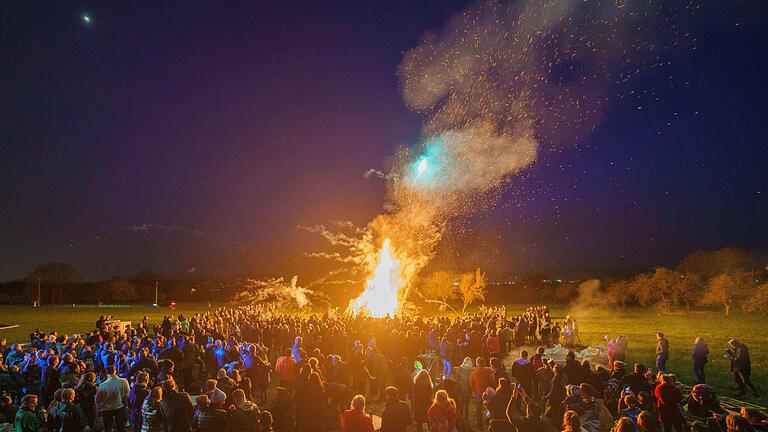 Menschen stehen um ein Osterfeuer - Das Osterfeuer ist für viele ein Highlight rund um die Ostertage. Man sollte aber Rücksicht auf die Natur nehmen. Menschen stehen um ein Osterfeuer - Das Osterfeuer ist für viele ein Highlight rund um die Ostertage. Man sollte aber Rücksicht auf die Natur nehmen.