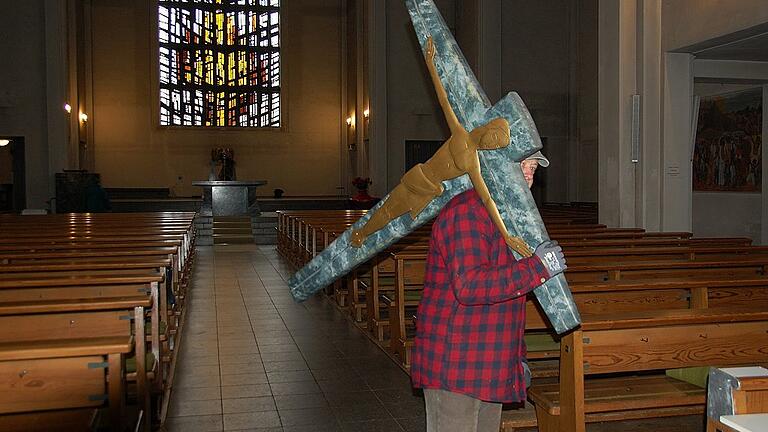 Ehrenamtliche Helfer räumten alle beweglichen Utensilien aus der Hauptkirche, auch dieses Kreuz, das Willi Hudert ins Lager schleppte.