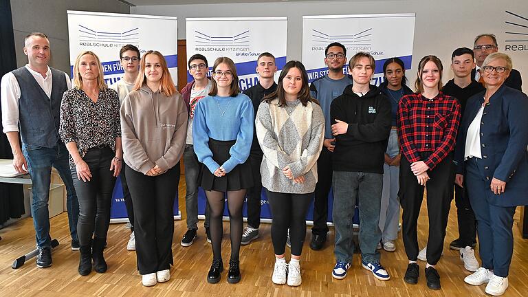 Feierstunde für Sprachgenies: Das Foto zeigt Robert Kolb (Lehrkraft an der RSK), Bettina Singler (stellvertr. Elternbeiratsvorsitzende), Urs Brückmann, Celine Burgemeister, Andreas Schleyer, Josipa Ereiz, Mika Preißner, Aylin Lichtenwald, Zion-Jordan Njeri, Norman Rückert, Adiya Merdzic, Amelie Plich, Lorenz Freudinger, Michael Rückel (Realschuldirektor), Kerstin Wirsing (Elternbeiratsvorsitzende).