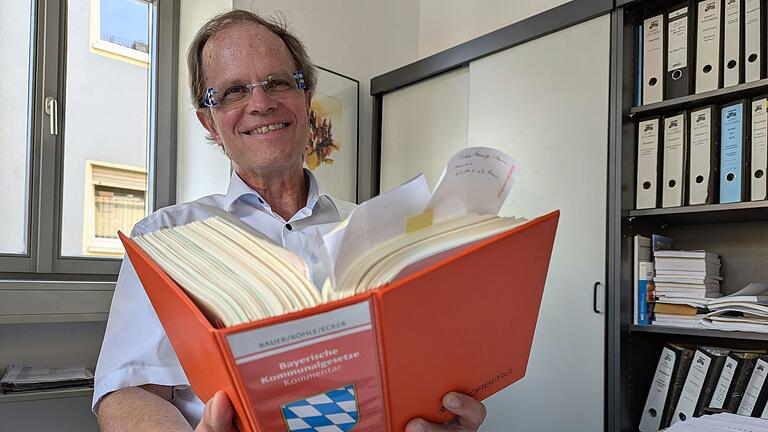 Höchbergs geschäftsleitender Beamter Gerd Waltinger sitzt kurz vor seinem Ruhestand in seinem Büro, mit einem seiner Lieblingsbücher in der Hand – es ist die Bayerische Gemeindeordnung. Höchbergs geschäftsleitender Beamter Gerd Waltinger sitzt kurz vor seinem Ruhestand in seinem Büro, mit einem seiner Lieblingsbücher in der Hand – es ist die Bayerische Gemeindeordnung.
