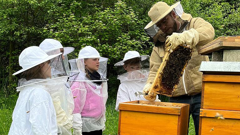 Sven Tönnies ('Honeylovers' Würzburg) mit einer der Gruppen der Drittklässler der Nachmittagsbetreuung der Grundschule Triefenstein am Bienenstock.