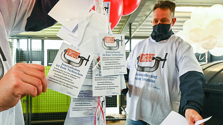 Eintreten für die Pressefreiheit: Diese Solidaritätskärtchen (hier mit BJV-Vertreter Ralph Bauer) trugen 100 weiße und rote Ballons in den Würzburger Himmel. Der starke Westwind trieb sie zumindest in Richtung Belarus.