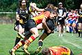 Ein Tackling – Ulrike Borchard vom Würzburger Rugby-Klub legt ihre Gegenspielerin geführt ab, indem sie sie umklammert und aushebt.