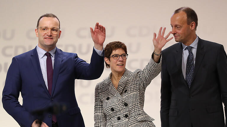 CDU Bundesparteitag - 07.12.2018, Hamburg: Die neue CDU-Vorsitzende Annegret Kramp-Karrenbauer steht zusammen mit ihren Mitbewerbern Jens Spahn (l) und Friedrich Merz nach ihrer Wahl auf dem CDU-Bundesparteitag auf der Bühne. Foto: Christian Charisius/dpa +++ dpa-Bildfunk +++ CDU Bundesparteitag - 07.12.2018, Hamburg: Die neue CDU-Vorsitzende Annegret Kramp-Karrenbauer steht zusammen mit ihren Mitbewerbern Jens Spahn (l) und Friedrich Merz nach ihrer Wahl auf dem CDU-Bundesparteitag auf der Bühne. Foto: Christian Charisius/dpa +++ dpa-Bildfunk +++