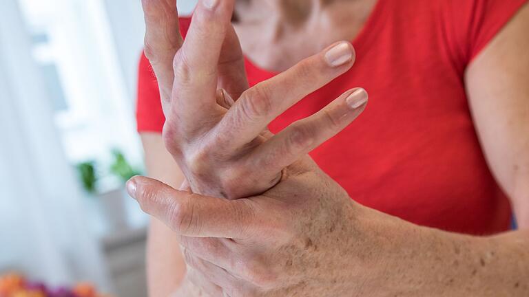 Eien Frau reibt sich ihre schmerzende Hand - Von Arthrose sind am häufigsten Knie- und Hüftgelenk betroffen. Doch auch an den Händen kann es zu Knorpelverschleiß kommen. Eien Frau reibt sich ihre schmerzende Hand - Von Arthrose sind am häufigsten Knie- und Hüftgelenk betroffen. Doch auch an den Händen kann es zu Knorpelverschleiß kommen.