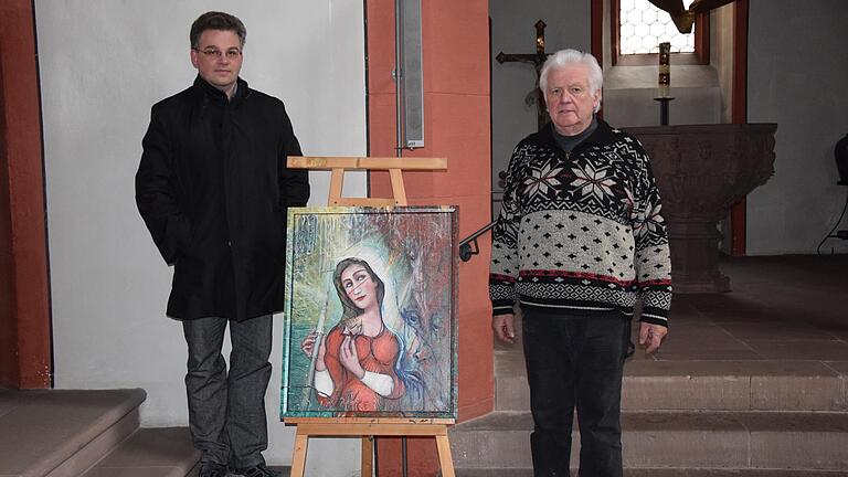 Vordergründig ein modernes Marienbild führt das von dem Künstler Josef Geißler (rechts) geschaffene Werk auch hinein in das Leiden Jesu am Kreuz und verweist hoffnungsvoll auf die Auferstehung. Das Bild ist in der Kirche St. Andreas in Karlstadt ausgestellt. Pfarrer Simon Mayer (links) hat zu dem Gemälde eine meditative Bildbetrachtung erstellt.