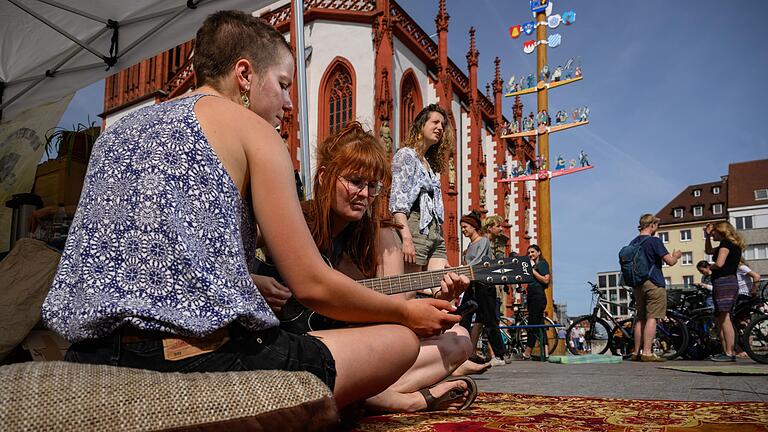 Zwei Aktivistinnen machen am Freitag vor dem Klima Camp am unteren Markt in Würzburg Musik. Unter dem Motto '24 Stunden für eine klimagerechtere Welt.' campierten die Aktivistinnen und Aktivisten am Wochenende an verschiedenen Orten in der Innenstadt.