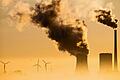 Kraftwerk und Windräder       -  Die 28 EU-Umweltminister haben dem Weltklimavertrag zugestimmt. Jetzt muss sich jedes EU-Land noch mehr anstrengen, um den CO2-Ausstoß zu verringern.