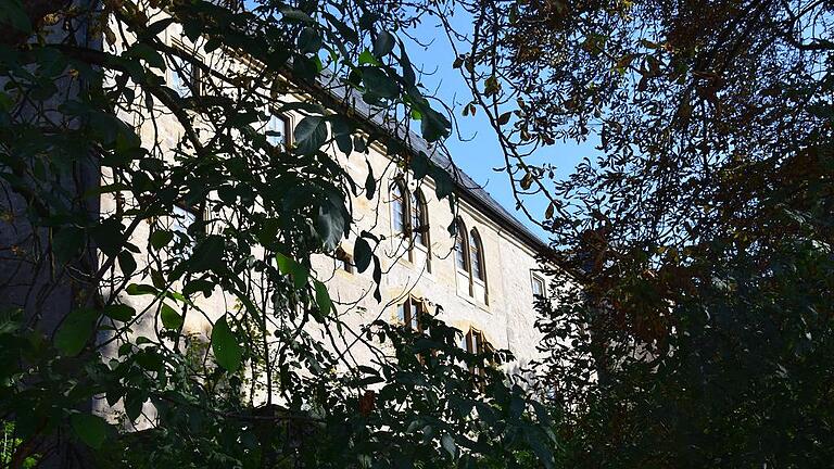 Dichter Baumbewuchs rund um das Schloss Wetzhausen, Stammsitz der Freiherren Truchseß von und zu Wetzhausen, verwehrt den Blick auf das stattliche vierstöckige Gebäude.