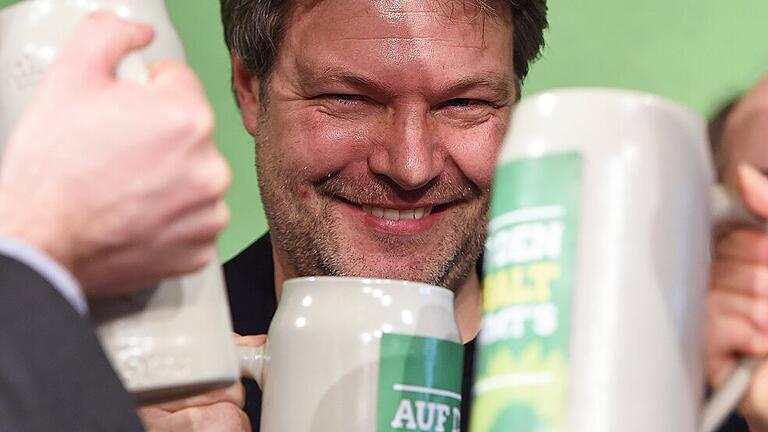 Mit Habeck, Söder und Esken: Aschermittwoch in bewegten Zeiten       -  Robert Habeck, Bundesvorsitzender von Bündnis 90/Die Grünen, trinkt nach seiner Rede auf dem politischen Aschermittwoch der Partei aus einem Maßkrug mit der Aufschrift &bdquo;Auf den Inhalt kommt's an&ldquo;.