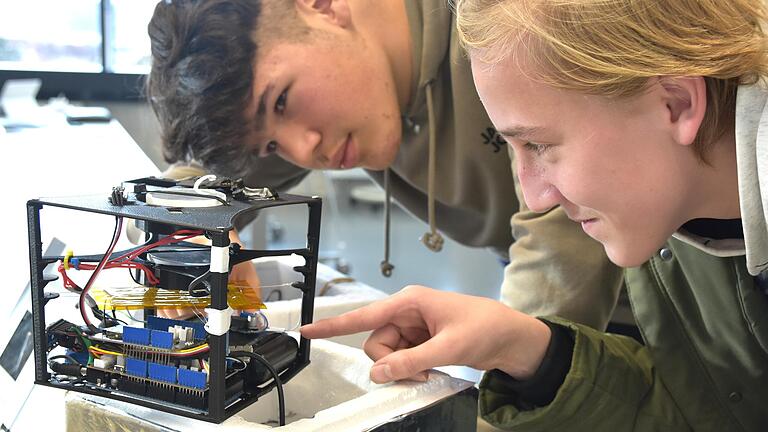 Interessiert untersuchen zwei Schüler der Realschule Dettelbach den Prototyp der Sonde.