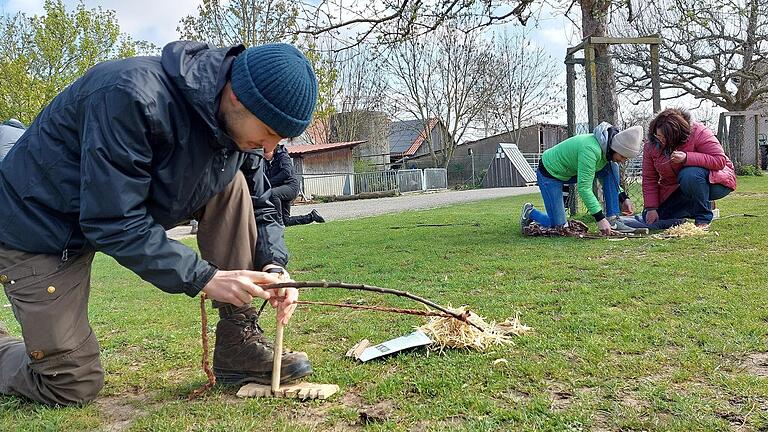 Beim 'Hizuna'-Projekt lernen Jugendliche und junge Erwachsene, wie man mit Geduld und Geschick ein Feuer entfacht: Durch schnelles Drehen von Holz auf Holz entsteht Reibungswärme, die das Bohrmehl zum Glühen bringen kann. Das Foto entstand im Frühjahr in Kitzingen.