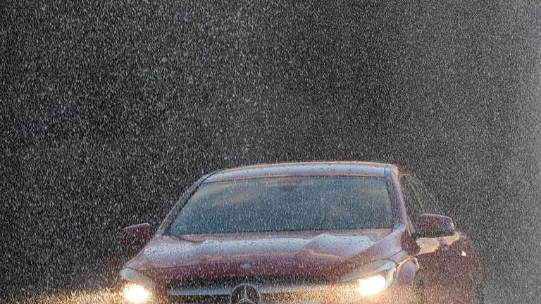 Autofahren im Starkregen Symbolbild       -  Auto im Regen: Im Jahr 2023 wartet der Gesetzgeber mit einigen Neuerungen für Autofahrer auf.