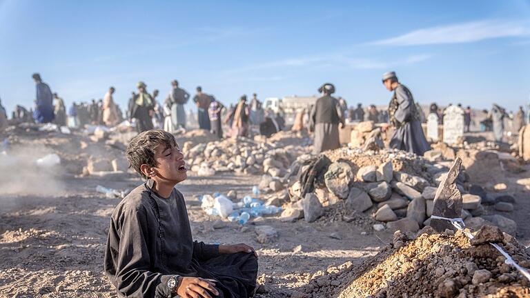 Junge in Afghanistan.jpeg       -  Ein Junge trauert neben dem Grab seines kleinen Bruders, der in der Provinz Herat im Westen Afghanistans ums Leben gekommen ist.