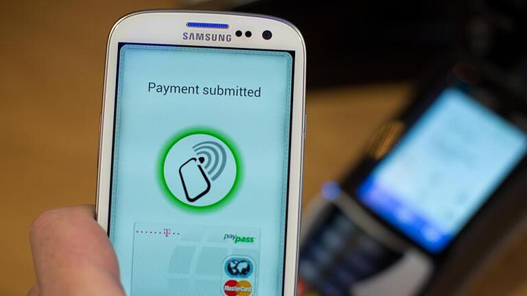 Handy mit Nahbereichskommunikationstechnik: Die NFC-Aufkleber oder -Anhänger erleichtern Smartphone-Nutzern den Tagesablauf. Foto: Michael Kappeler - Nahbereichskommunikationstechnik: NFC-fähige Smartphones können den Alltag erleichtern. Handy mit Nahbereichskommunikationstechnik: Die NFC-Aufkleber oder -Anhänger erleichtern Smartphone-Nutzern den Tagesablauf. Foto: Michael Kappeler - Nahbereichskommunikationstechnik: NFC-fähige Smartphones können den Alltag erleichtern.