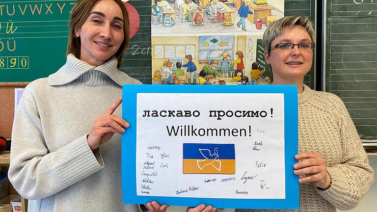 Schulleiterin Marietta Menz (links) und Klassenlehrerin Barbara Wieber aus der Bad Kissinger Sinnberg-Grundschule mit dem Willkommensschild, das Viertklässler für ihren neuen Mitschüler aus der Ukraine gebastelt haben. Schulleiterin Marietta Menz (links) und Klassenlehrerin Barbara Wieber aus der Bad Kissinger Sinnberg-Grundschule mit dem Willkommensschild, das Viertklässler für ihren neuen Mitschüler aus der Ukraine gebastelt haben.