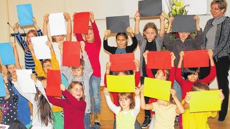 Blau-Weiß-Rot und Schwarz-Rot-Gold: Die Schüler der Grundschule Haßfurt überraschten mit einem französischen Lied und hielten am Schluss die Farben der beiden Nationalflaggen hoch.FOTO: Günther Geiling Blau-Weiß-Rot und Schwarz-Rot-Gold: Die Schüler der Grundschule Haßfurt überraschten mit einem französischen Lied und hielten am Schluss die Farben der beiden Nationalflaggen hoch.FOTO: Günther Geiling