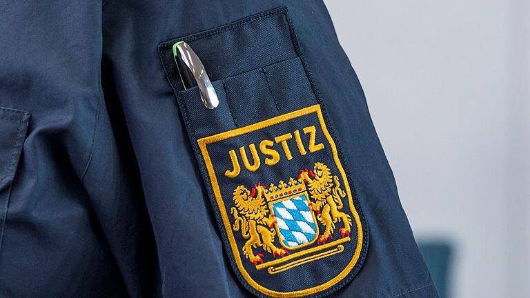 Justizbeamter       -  Auf der Uniform eines Justizbeamten ist das Bayerische Wappen und die Aufschrift „Justiz“ zu sehen. Betrüger geben sich immer wieder als falsche Justiz-Mitarbeiter aus. (Symbolbild)
