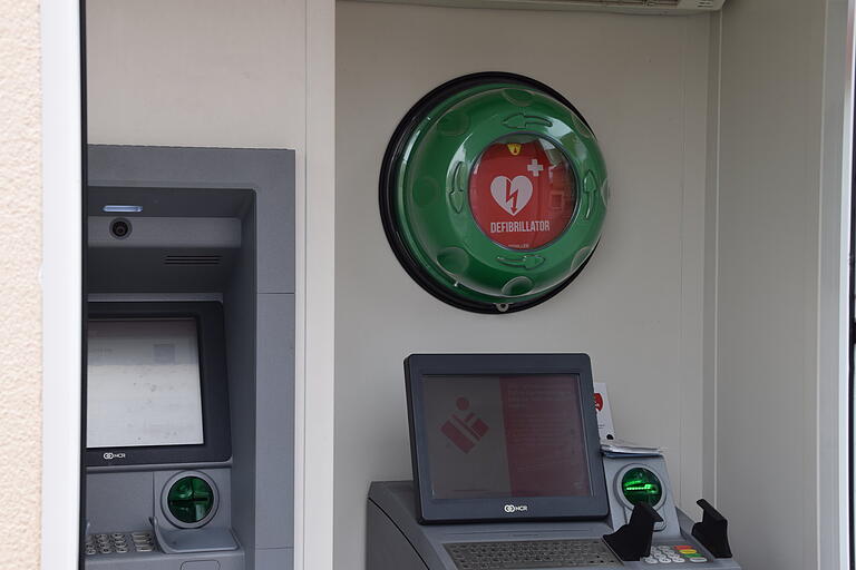 Geschützt durch einen leicht abnehmbaren grünen Deckel befindet sich der Sulzheimer Defibrillator neben dem Geldautomat im Sparkassenhäuschen. Geschützt durch einen leicht abnehmbaren grünen Deckel befindet sich der Sulzheimer Defibrillator neben dem Geldautomat im Sparkassenhäuschen.