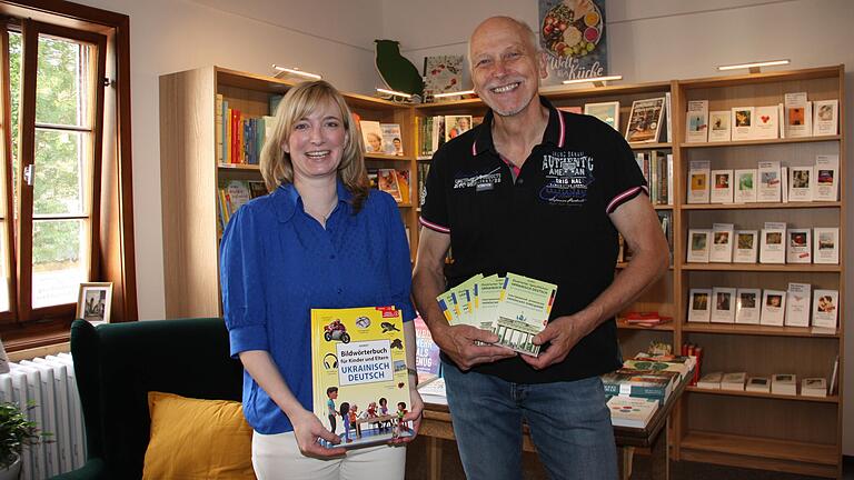 Julia Gellhaus, Inhaberin der Buchhandlung im Teutschhaus, und Zweiter Bürgermeister Erich Servatius als Vertreter des Helferkreises zeigen Wörterbücher, die im Rahmen der Spendenaktion für ukrainische Geflüchtete zusammenkamen.