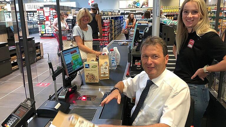 Bürgermeister Thomas Helblings Ehefrau Sabine ließ es sich nicht nehmen, als erste die Kasse anzusteuern, an der ihr Mann für eine Stunde Dienst tat. Rewe-Mitarbeiterin Anna Schenk (recht) unterstützte den Bürgermeister bei seiner ungewohnten Tätigkeit. Bürgermeister Thomas Helblings Ehefrau Sabine ließ es sich nicht nehmen, als erste die Kasse anzusteuern, an der ihr Mann für eine Stunde Dienst tat. Rewe-Mitarbeiterin Anna Schenk (recht) unterstützte den Bürgermeister bei seiner ungewohnten Tätigkeit.