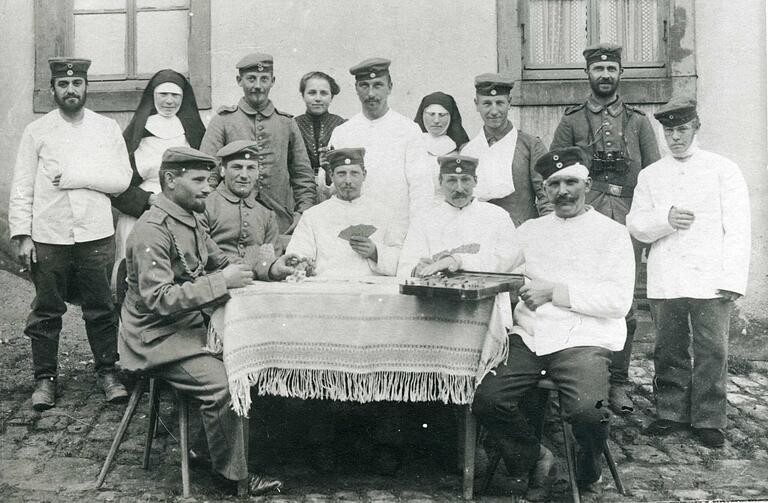 Engelbert Fella aus Weyersfeld (am Tisch links) spielt im Herbst 1914 mit anderen Verwundeten des Ersten Weltkriegs vor dem alten Spital in Gemünden Karten. Engelbert Fella aus Weyersfeld (am Tisch links) spielt im Herbst 1914 mit anderen Verwundeten des Ersten Weltkriegs vor dem alten Spital in Gemünden Karten.