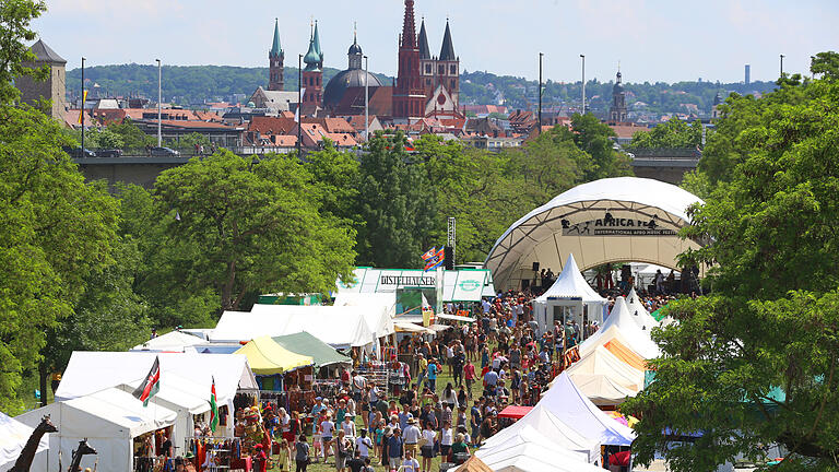 Würzburger Africa-Festival - 31.05.2018, Bayern, Würzburg: Besucher des Africa-Festivals laufen vor der großen Bühne auf den Mainwiesen. Die viertägige Veranstaltung mit rund 250 Künstler gilt als das größte Festival für afrikanische Musik und Kultur in Europa. Würzburger Africa-Festival - 31.05.2018, Bayern, Würzburg: Besucher des Africa-Festivals laufen vor der großen Bühne auf den Mainwiesen. Die viertägige Veranstaltung mit rund 250 Künstler gilt als das größte Festival für afrikanische Musik und Kultur in Europa.