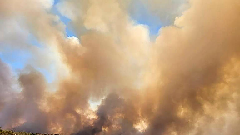 Hitze-in-Griechenland.jpg       -  Dichte Rauchwolken eines Waldbrandes steigen auf der griechischen Insel Rhodos in den Himmel.