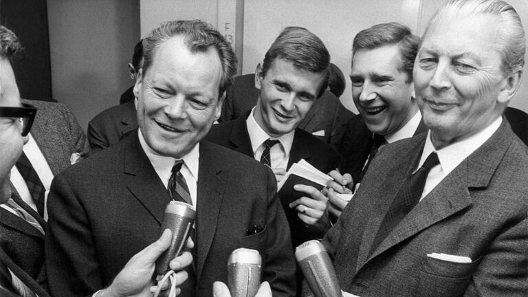 Große Koalition - Die erste „Groko”: CDU-Kanzlerkandidat Kurt Georg Kiesinger und SPD-Chef Willy Brandt besiegeln 1966 das Bündnis aus Union und Sozialdemokraten, die zusammen auf fast 87 Prozent der Stimmen kamen (2021: 50 Prozent). Große Koalition - Die erste „Groko”: CDU-Kanzlerkandidat Kurt Georg Kiesinger und SPD-Chef Willy Brandt besiegeln 1966 das Bündnis aus Union und Sozialdemokraten, die zusammen auf fast 87 Prozent der Stimmen kamen (2021: 50 Prozent).