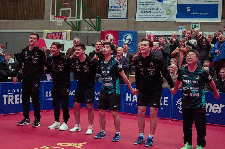 Bad Königshofens Tischtennis-LIeblinge feiern mit den Fans den 3:1-Sieg gegen Bergneustadt (von links): Kilian Ort, Bastian Steger (beide verletzt), Martin Allegro, Jin Ueda, Filip Zeljko und Trainer Koji Itagaki. Bad Königshofens Tischtennis-LIeblinge feiern mit den Fans den 3:1-Sieg gegen Bergneustadt (von links): Kilian Ort, Bastian Steger (beide verletzt), Martin Allegro, Jin Ueda, Filip Zeljko und Trainer Koji Itagaki.