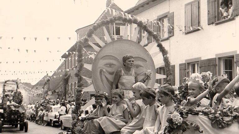 Vom prächtigen Sonnenwagen winkten Monika Hochrein und ihre Schwester Birgit zusammen mit anderen Mädchen 1964 den Volkacher Weinfestbesuchern zu.
