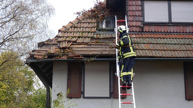Die Feuerwehr entfernte lose Dachziegel von dem beschädigten Haus in Ermershausen.