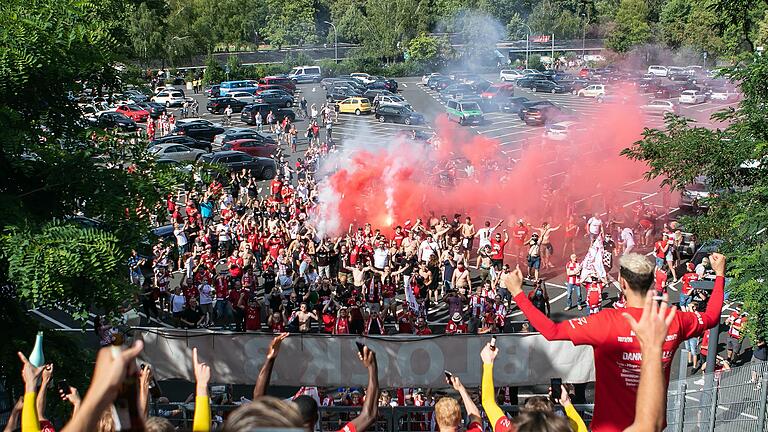 Während die Spieler der Würzburger Kickers im Vordergrund den Aufstieg feierten, brannten einige Fans vor dem Stadion Pyrotechnik ab. Während die Spieler der Würzburger Kickers im Vordergrund den Aufstieg feierten, brannten einige Fans vor dem Stadion Pyrotechnik ab.