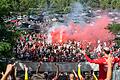 Während die Spieler der Würzburger Kickers im Vordergrund den Aufstieg feierten, brannten einige Fans vor dem Stadion Pyrotechnik ab.