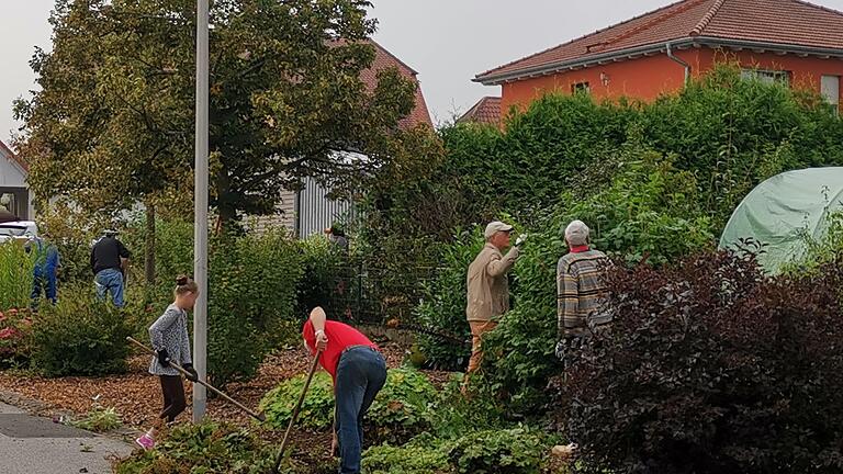 Freiwillige Helfer des Obst- und Gartenbauvereins kümmern sich um Grünflächen im Ort. Aura soll im Rahmen der Dorferneuerung noch grüner werden.       -  Freiwillige Helfer des Obst- und Gartenbauvereins kümmern sich um Grünflächen im Ort. Aura soll im Rahmen der Dorferneuerung noch grüner werden.