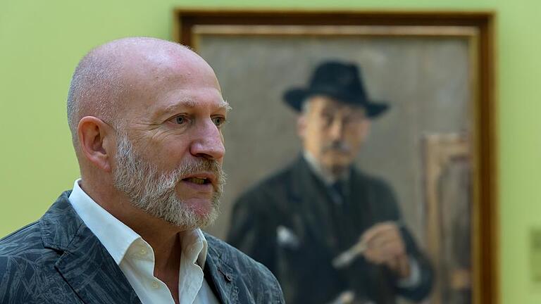 Museumsleiter Wolf Eiermann vor einem Selbstporträt von Max Liebermann.