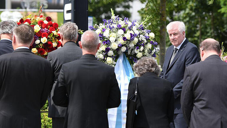 Nach Schießerei in München       -  Der bayerische Ministerpräsident Horst Seehofer (CSU, r) legt am 23.07.2016 am Olympia-Einkaufszentrum in München (Bayern) einen Kranz nieder, einen Tag nach einer Schießerei mit Toten und Verletzten. Die tödlichen Schüsse hat ein 18-jähriger Deutsch-Iraner abgegeben. Zehn Menschen starben, darunter der Täter.