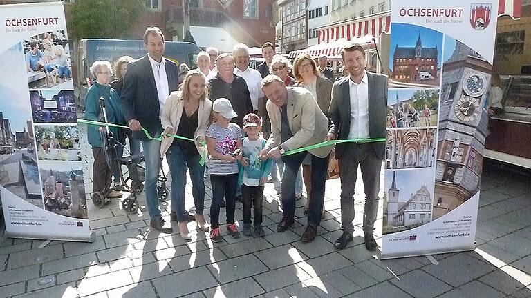 Zur Eröffnung des Wochenmarktes durfte Jana aus Ochsenfurt das grüne Band durchschneiden. Unterstützt wurde sie dabei von ihrem Bruder Luis, Anne Derday (links) und Bürgermeister Peter Juks (rechts). Zur Eröffnung des Wochenmarktes durfte Jana aus Ochsenfurt das grüne Band durchschneiden. Unterstützt wurde sie dabei von ihrem Bruder Luis, Anne Derday (links) und Bürgermeister Peter Juks (rechts).