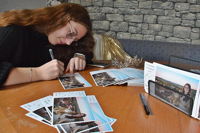An die 350 Autogrammkarten unterschreibt die Christkind-Darstellerin, Lara Werner, aus Eyershausen zurzeit. Gleich nebenan das Christkind-Gewand mit Krone. An die 350 Autogrammkarten unterschreibt die Christkind-Darstellerin, Lara Werner, aus Eyershausen zurzeit. Gleich nebenan das Christkind-Gewand mit Krone.