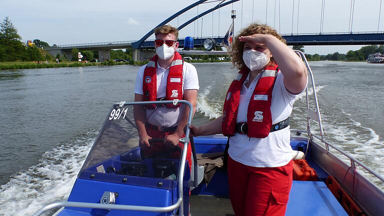 Janik Schanz und Sylvia Voit beobachten auf dem Dienstboot der Volkacher Wasserwacht den Badebetrieb auf dem Main.