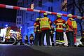 Lagebesprechung: Rettungskräfte und Feuerwehreinsatzkräfte stehen vor der Tiefgarage des CCW in Würzburg.