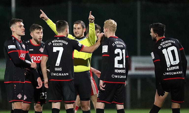 Diskussion zwischen Spielern der Würzburger Kickers und dem Schiedsrichter im hitzigen Pokal-Viertelfinale in Großschwarzenlohe. Vorausgegangen war eine Rote Karte gegen Marius Wegmann (links).