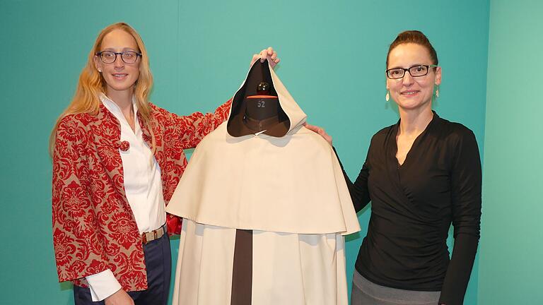 Museumschefin Carola Marie Schmidt (links) und Kuratorin Ludmila Kvapilová-Klüserner präsentieren ein Original-Ordensgewand der Karmeliten. Museumschefin Carola Marie Schmidt (links) und Kuratorin Ludmila Kvapilová-Klüserner präsentieren ein Original-Ordensgewand der Karmeliten.