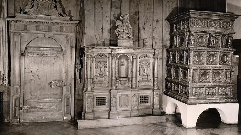 Westseite der Ratsstube, auf dem Aktenschrank von 1625 die Figur des Stadtpatrons St. Georg. Daneben der leider 1960 entfernte Kachelofen. Die Aufnahme ist von Paul Meder 1970. Westseite der Ratsstube, auf dem Aktenschrank von 1625 die Figur des Stadtpatrons St. Georg. Daneben der leider 1960 entfernte Kachelofen. Die Aufnahme ist von Paul Meder 1970. 