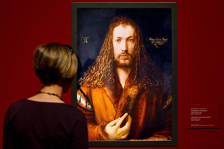 Eine Frau bestaunt im Germanischen Nationalmuseum in Nürnberg eine Reproduktion des Gemäldes 'Selbstbildnis im Pelzrock' von Albrecht Dürer aus dem Jahr 1500. Das Foto stammt von einer Ausstellung im Jahr 2012.