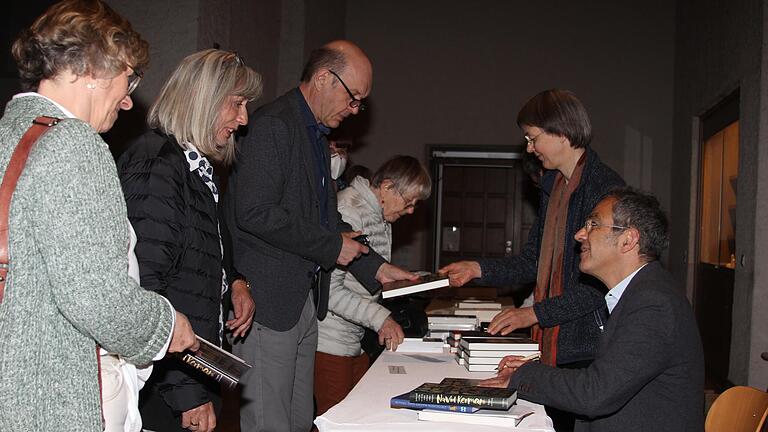 Nach der Autorenlesung hatten die Besucher in der Münsterschwarzacher Abteikirche Gelegenheit, das Buch 'Jeder soll von da, wo er ist, einen Schritt näher kommen' von Navid Kermani signieren zu lassen.