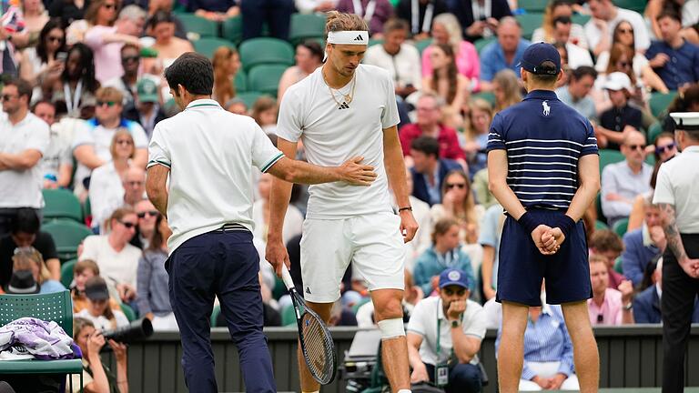 Wimbledon 2024       -  Alexander Zverev (r) geht zurück auf den Platz, nachdem ihm nach seinem Sturz ein Verband um sein Knie gewickelt worden ist.