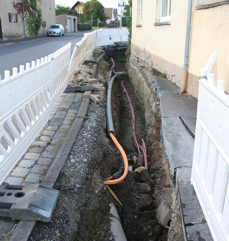 Beim Aufgraben der Gehwege kamen, wie hier in der Grettstadter Straße, eine Reihe von Versorgungsleitungen, etwa für Telefon und Strom, sowie Kanalleitungen zum Vorschein, von denen niemand mehr etwas wusste. Dies verzögerte und erschwerte das Verlegen der Wärmeleitungen zusätzlich.