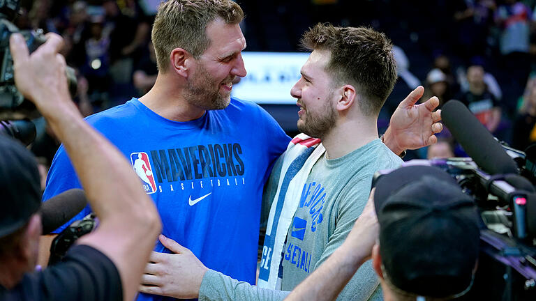 Die Würzburger Basketball-Legende Dirk Nowitzki (links) umarmt, Luka Doncic, den Starspieler der Dallas Mavericks, die elf Jahre nach der Meisterschaft mit Nowitzki erstmals wieder Chancen auf den Titel haben - diesmal mit dem Würzburger Maxi Kleber.