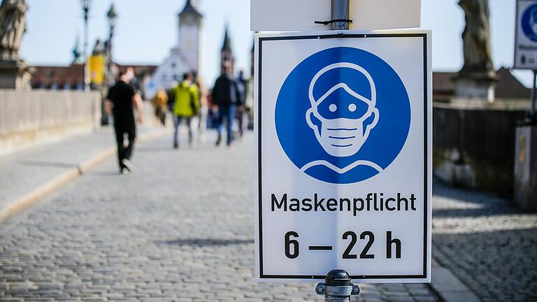 Hat erst im Juni 2021 ausgedient: Ein Schild weist auf die Maskenpflicht auf der Alten Mainbrücke in Würzburg hin.